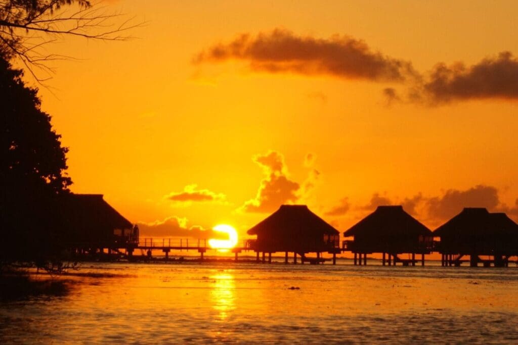 Sunset with overwater bungalows in Tahiti